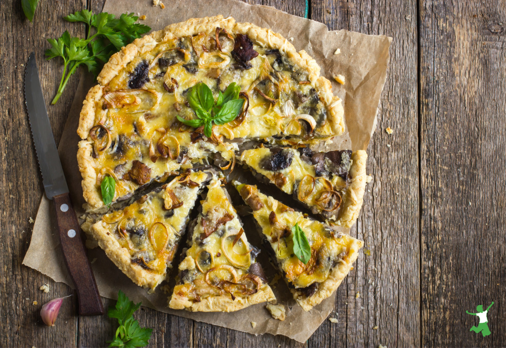 homemade quiche made with leftovers on wooden table with knife