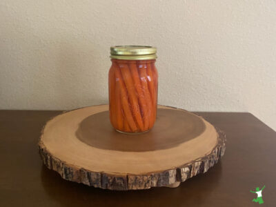 fermented carrot sticks in mason jar on wooden table