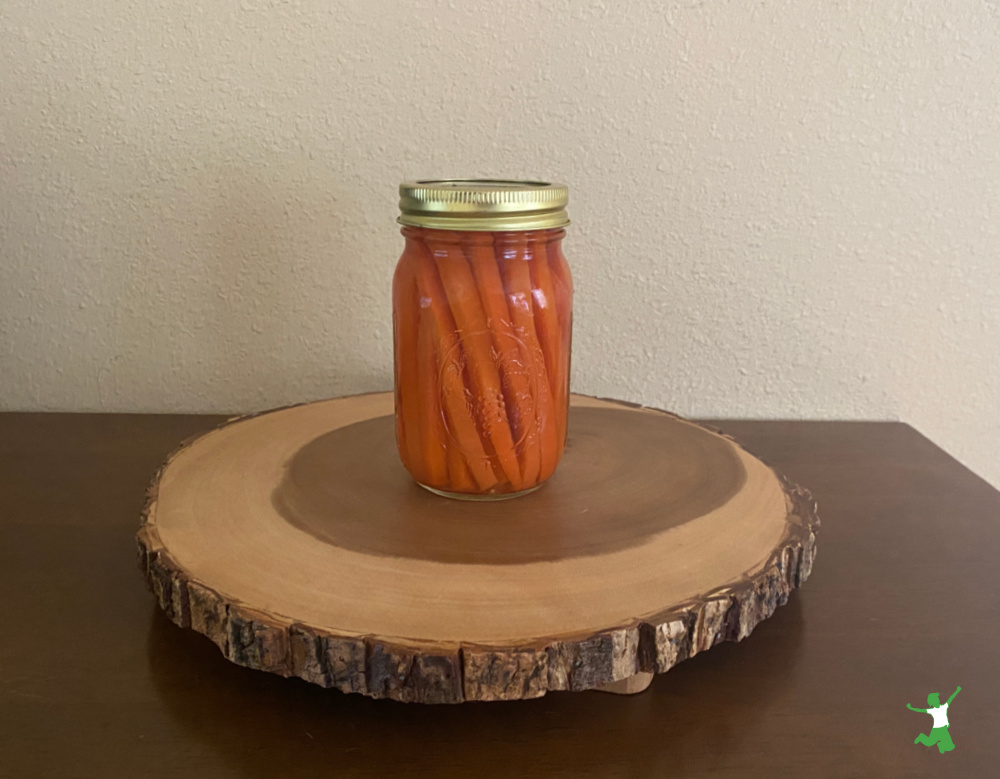 fermented carrot sticks in mason jar on wooden table