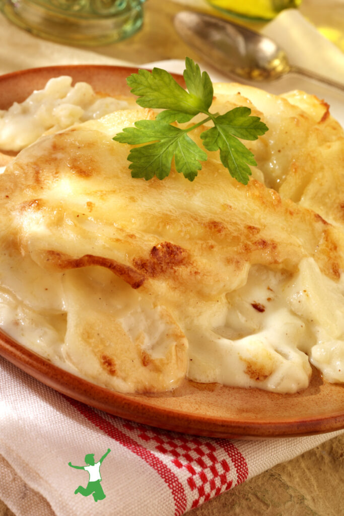 garlic au gratin potatoes on terra cotta plate with garnish