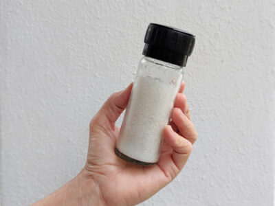 unrefined white sea salt in a glass grinder