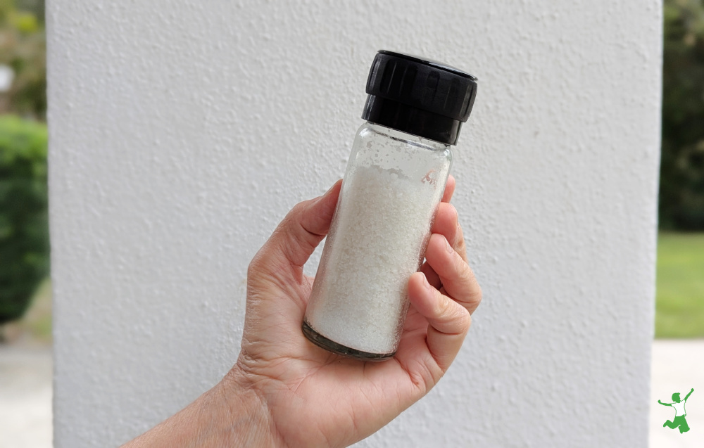 unrefined white sea salt in a glass grinder