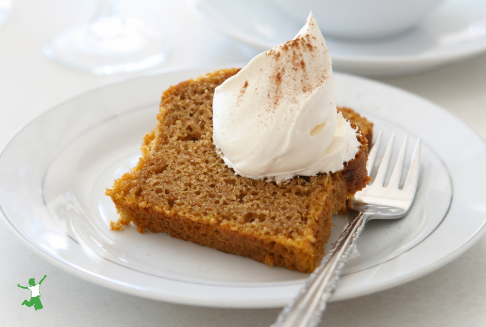 healthy slice of pumpkin bread with whipped cream on a plate