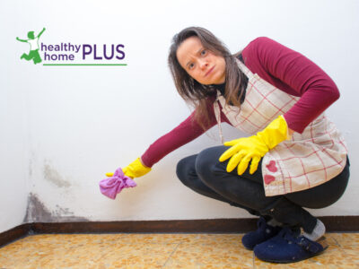 woman cleaning mold from her kitchen walls