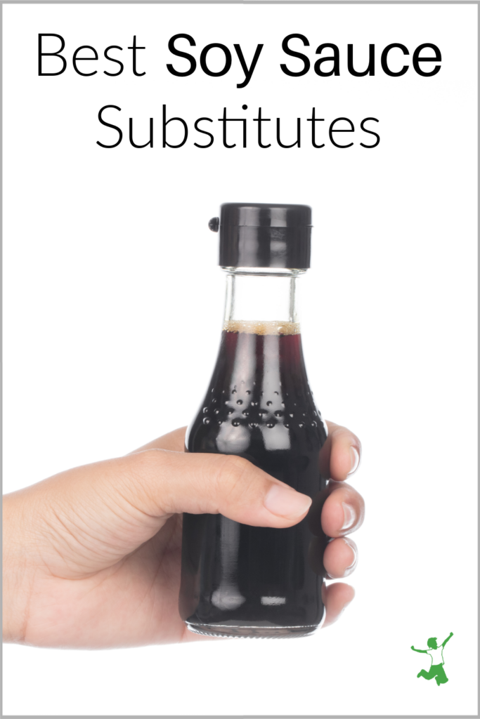 woman holding homemade soy sauce substitute in glass bottle